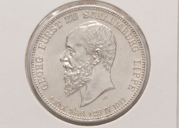 Nahaufnahme der Vorderseite: Porträt von Fürst Georg zu Schaumburg-Lippe im Profil nach links. Die Inschrift mit den Lebensdaten und der Prägebuchstabe „A“ sind klar definiert. Die Münze zeigt einen attraktiven Silberglanz.