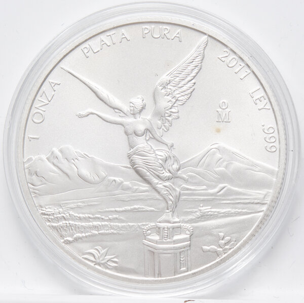 Nahaufnahme der Vorderseite der 1 Unze Silber Libertad 2011. Die geflügelte Siegesgöttin auf ihrer Säule ist scharfkantig und brillant abgebildet, im Hintergrund die feinen Konturen der Vulkane.