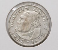 Die Rückseite zeigt den deutschen Reichsadler in klassischer Gestaltung. Die Umschrift „Deutsches Reich“ und der Nennwert „2 Reichsmark“ in Frakturschrift umrahmen das Motiv. Zwischen den Worten befinden sich dezente Eichenblätter. Unter dem Adler ist deutlich das Münzzeichen „D“ für München zu erkennen.