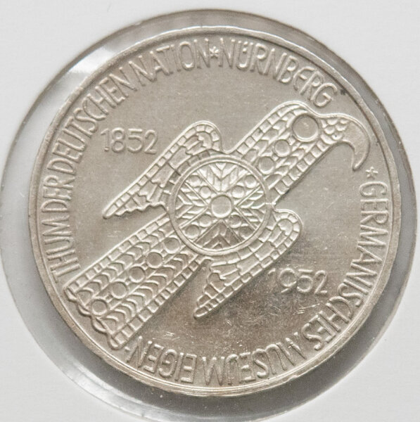 Vorderseite der 5-DM-Gedenkmünze 1952 „Germanisches Museum“ mit der Darstellung der Adlerfibel. Deutlich erkennbare Details der Prägung und natürliche Silber-Patina.