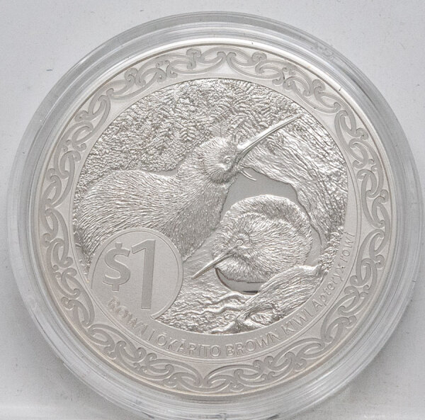 Runde Münze mit geprägtem Adler-Motiv, Spiegelnder Hintergrund mit matten Reliefs.