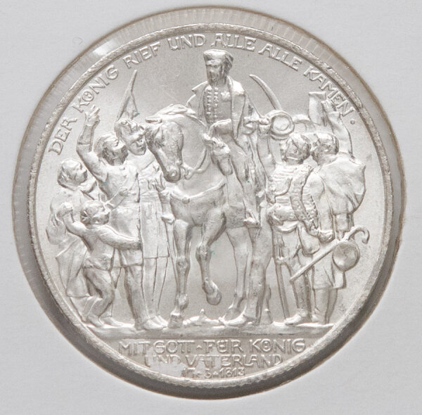 Nahaufnahme der Motivseite der 2-Mark-Silbermünze von 1913. Gezeigt wird die dynamische Volksszene mit dem reitenden König Friedrich Wilhelm III. im Zentrum. Die feinen Details der umstehenden Personen und die Inschrift DER KÖNIG RIEF UND ALLE ALLE KAMEN sind sehr gut erhalten und klar lesbar.