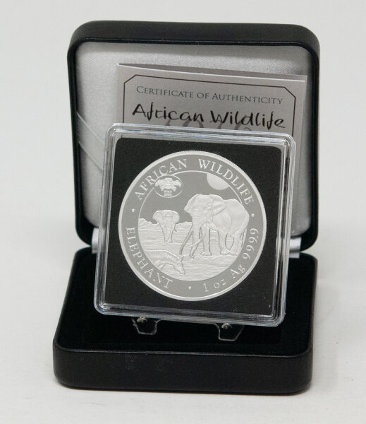 Gesamtansicht der Silbermünze im geöffneten, edlen Etui mit dem danebenliegenden Echtheitszertifikat, das die Limitierung von 1.000 Stück bestätigt.