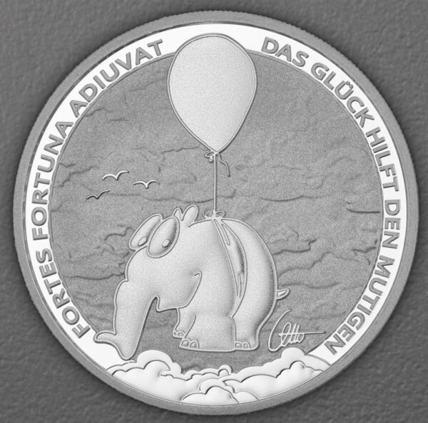 Die Motivseite der silbernen 1oz Gedenkmünze zeigt den detailreichen Ottifanten-Ballonifanten schwebend über den Wolken samt dem lateinischen und deutschen Sinnspruch sowie dem Otto-Signet.